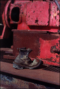 Weathered boot sitting on old oil drilling equipment